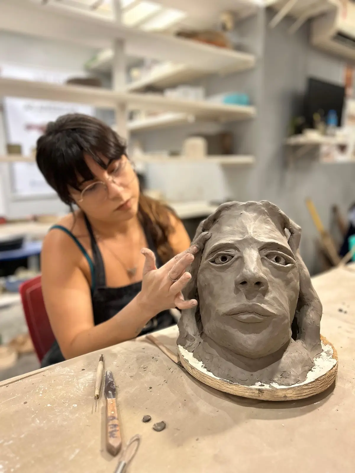 Una persona lavora a una scultura nella MUD Escola de Cerâmica